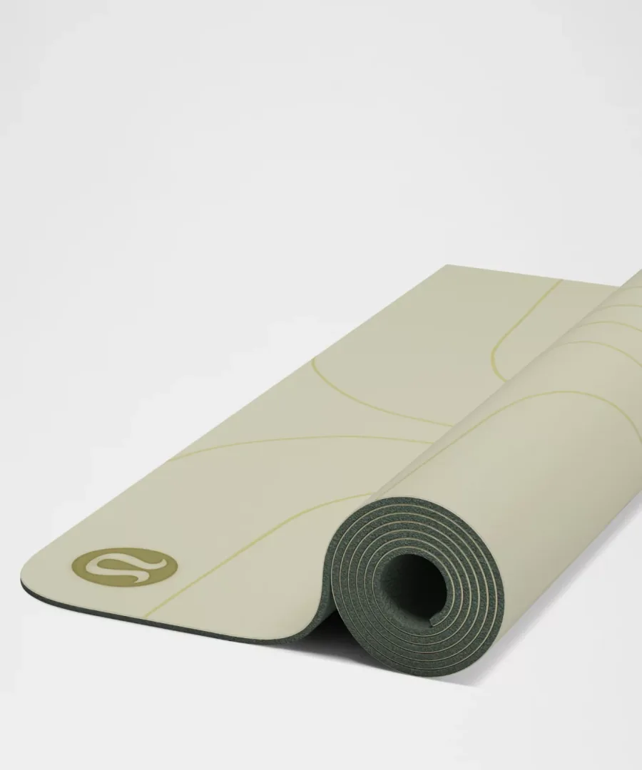 lululemon Align mat partly unrolled, showing the green natural-rubber underside coil and the alignment lines