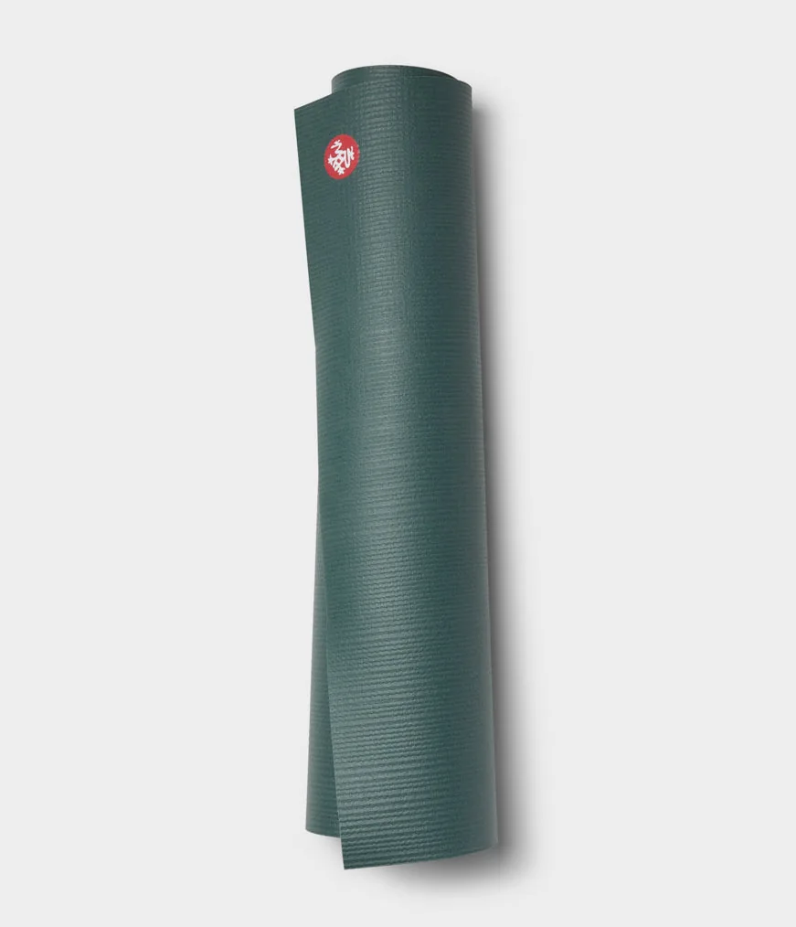 Manduka PRO 6mm yoga mat in Black Sage, rolled and standing
